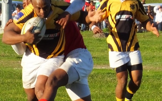 Die binnesenter, Lodewyk Fourie, is hier op die aanval terwyl buitesenter, Steward Jacobs opvolg. Black Leaves se 1ste-span het met 23/18 teen Bredasdorp verloor, terwyl die 2de-span met 13 elk gelykop gespeel het.  